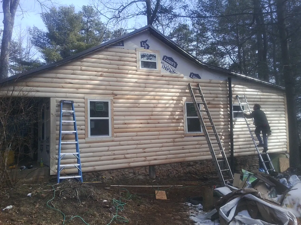 Ladders set against fresh log siding during an exterior remodel in Middle River