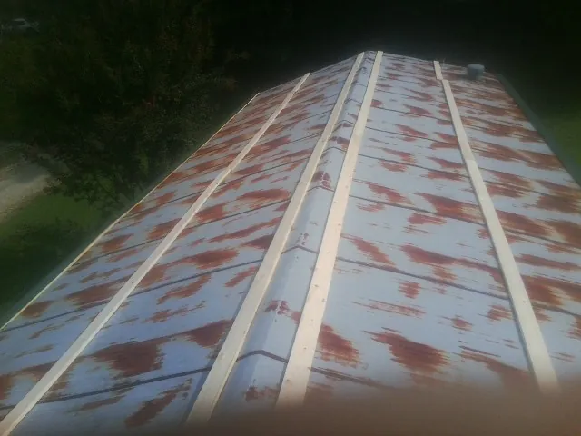 Rusted metal roof panels with new wood purlins before replacement — Storm Damage Roof Repair in Middle River by Roofing Brothers