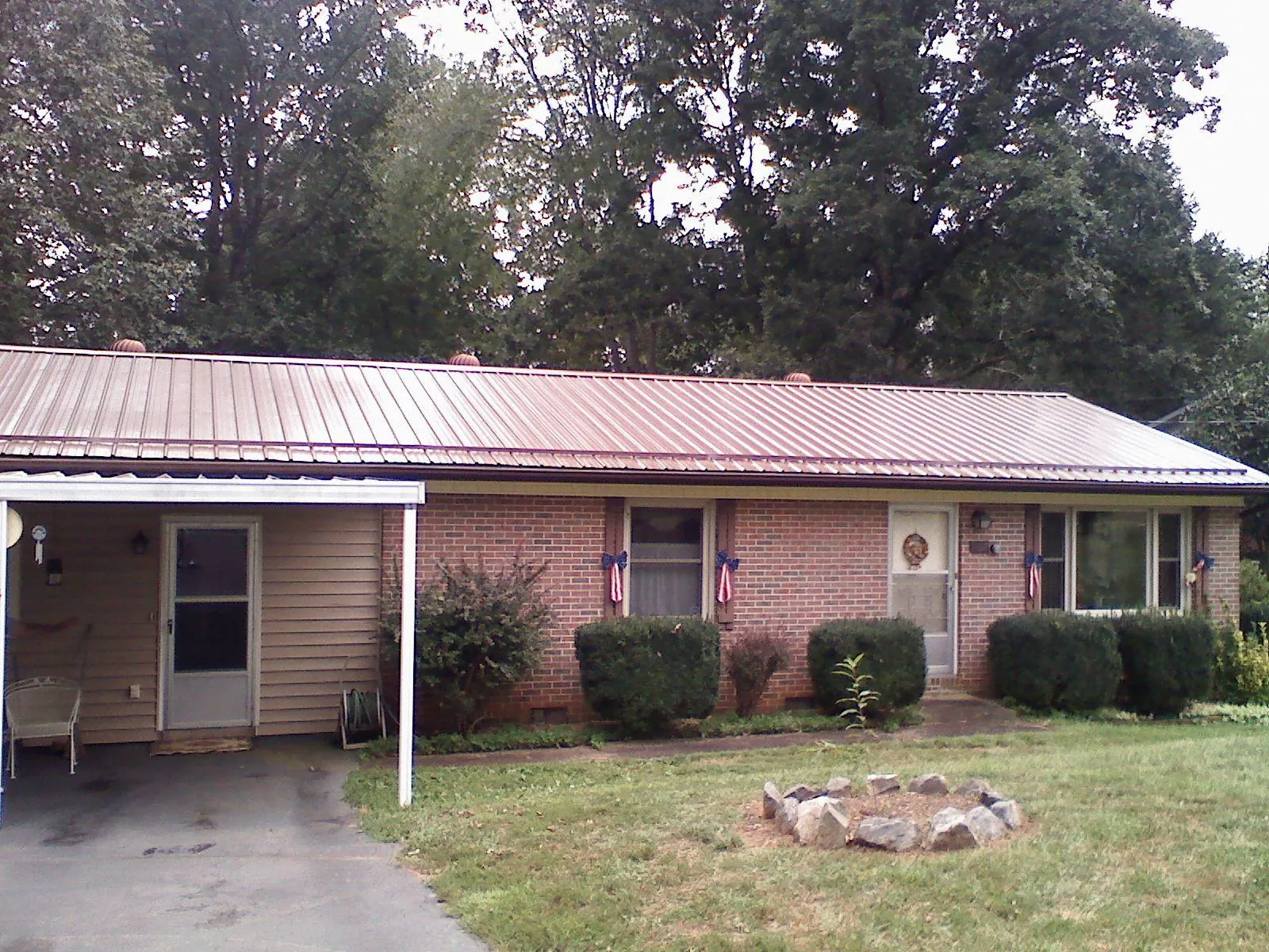 Bronze metal roof and carport on a brick ranch home — Roof Repair work by our crew in Middle River