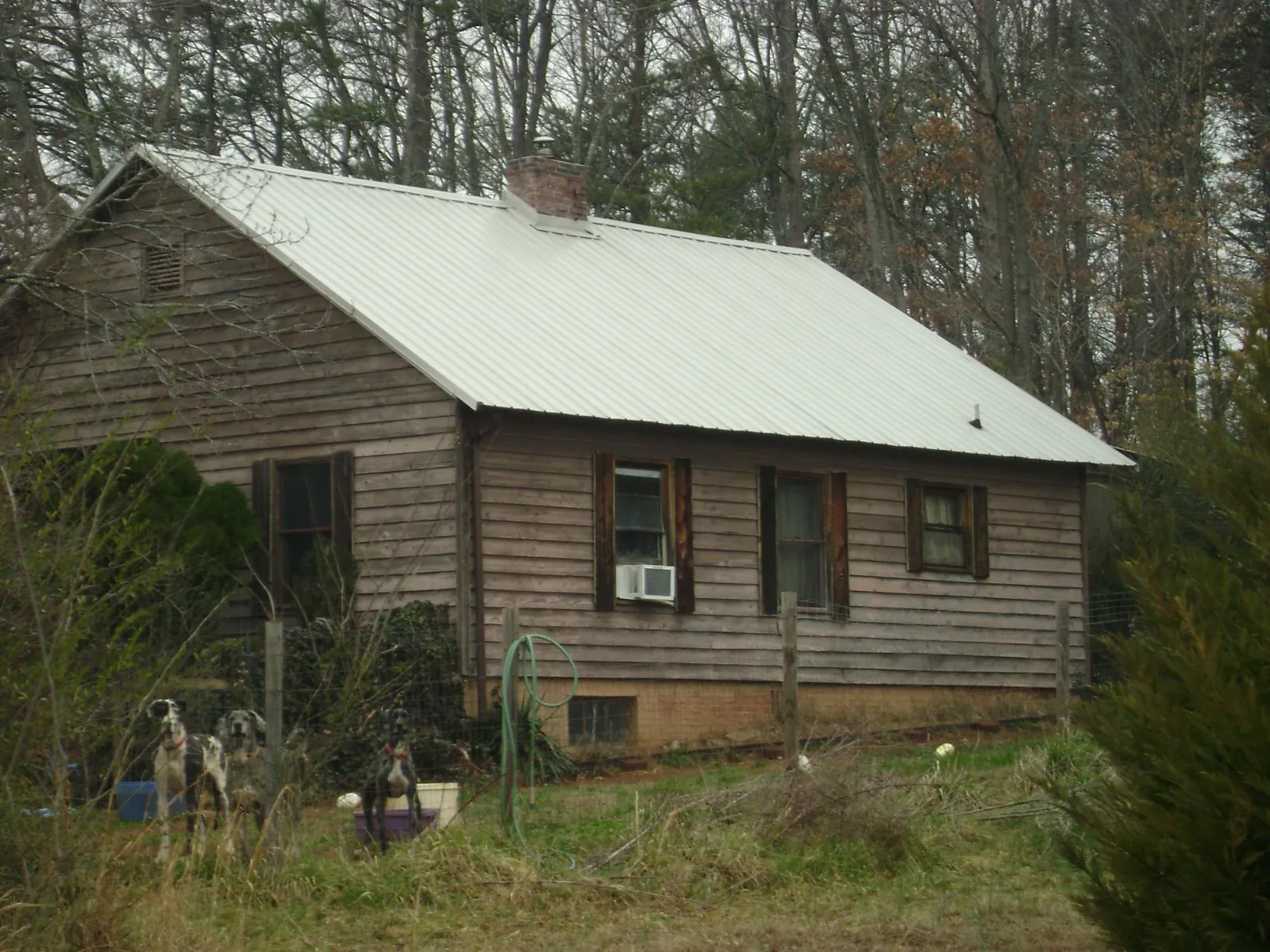 White metal roof on an old wood sided farmhouse, from a Metal Roof Installation job in Middle River